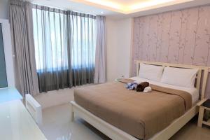 a bedroom with a bed with a stuffed animal on it at Baanpoon Apartment in Chaweng