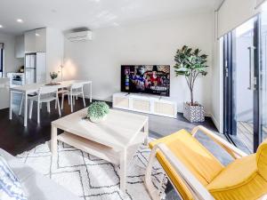 sala de estar con sofá y mesa en Modern 3-level Townhouse FreeParking en Melbourne