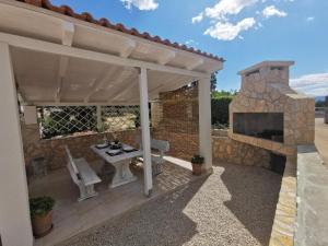 a patio with a stone fireplace and a table and chairs at Apartments Lea with pool 2 in Malinska