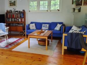 uma sala de estar com um sofá azul e uma mesa em Holiday home MARIEFRED IX em Mariefred