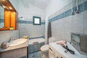 bagno con lavandino, servizi igienici e TV di The Square Suites 2nd floor apartment ad Argostoli Altre 44 foto