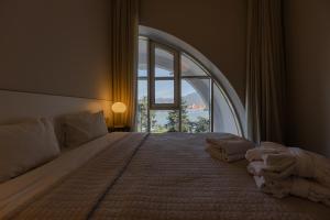 a bedroom with a large bed with a large window at Le Port Boutique Apart Hotel in Batumi