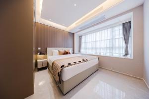 Giường trong phòng chung tại Xi Ke Executive Apartment - Shenzhen Futian Exhibition Center
