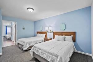 2 łóżka w pokoju z niebieskimi ścianami w obiekcie The Sand Dunes w mieście Kure Beach