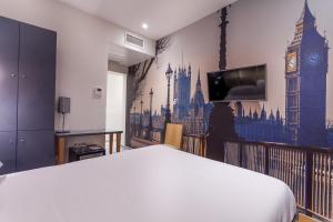 a bedroom with a bed and a tv and big ben at Hotel Jenner in Paris
