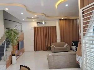 uma sala de estar com um sofá e uma televisão em Villa duplex meublée piscine à Akpakpa ciné concorde em Cotonou