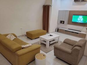 un soggiorno con due divani e una TV di Villa duplex meublée piscine à Akpakpa ciné concorde a Cotonou Altre 2 foto
