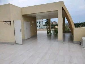 um grande pátio com mesas e cadeiras num edifício em Villa duplex meublée piscine à Akpakpa ciné concorde em Cotonou