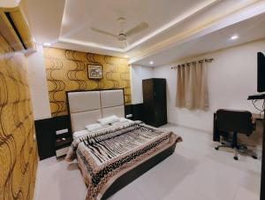 a bedroom with a bed and a desk and a chair at Lijoy Hotel & Restra in Būndi