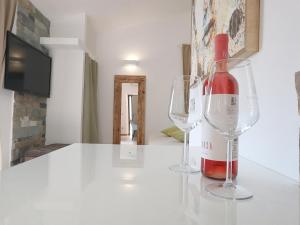 una bottiglia di vino e due bicchieri da vino su un bancone di Borgo del Nespolo a Peschici