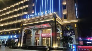 a building with a sign on the side of it at Mehood Hotel Xiangyang Wanda Plaza Railway Station in Xiangyang