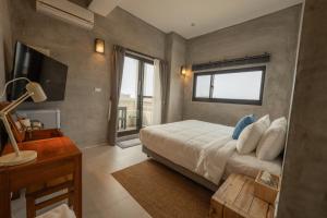 Un dormitorio con una cama grande y una ventana en Serendipity House澎湖望安島 en Wang-an