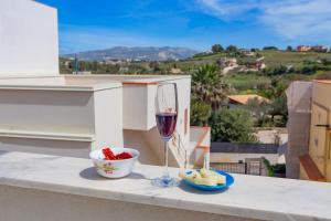 a glass of wine and a bowl of fruit on a ledge at A'Mari - Holiday Home - Sciacca - 100mt dalla spiaggia Foggia - 100 meters from the beach in Sciacca