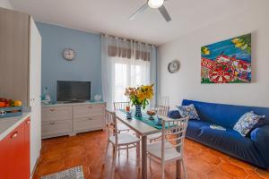 een woonkamer met een blauwe bank en een tafel bij A'Mari - Holiday Home - Sciacca in Sciacca