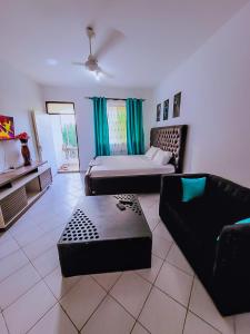 ein Wohnzimmer mit einem Bett und einem Sofa in der Unterkunft Dasha Studio apartment Bamburi D4 in Bamburi