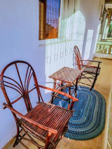 two wooden chairs and a table on a rug at Dasha Studio apartment Bamburi D4 in Bamburi