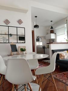 Il dispose d'une cuisine et d'un salon avec une table et des chaises blanches. dans l'établissement Casa Flora appartamento con giardino, à Fiumicino