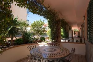 a patio with a table and chairs and plants at World Village Apartments in Diano Marina