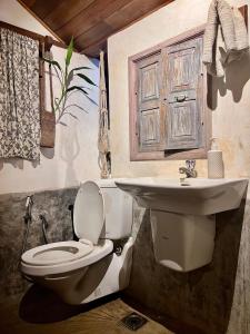 a bathroom with a toilet and a sink at Svarna Heritage in Kalyānpur +35 photos