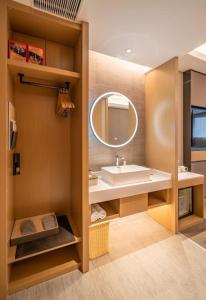 a bathroom with a sink and a mirror at Atour Hotel Shenzhen Luohu Vientiane City in Shenzhen