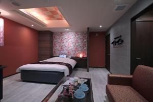 名古屋市にあるM'z HOTELのベッドルーム1室(ベッド1台、テーブル、ソファ付)