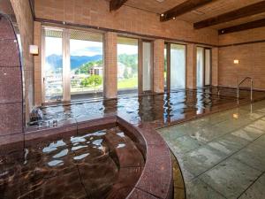une grande chambre avec piscine d'eau dans un bâtiment dans l'établissement KKR Yuzawa Yukiguni, à Yuzawa 34 autres photos