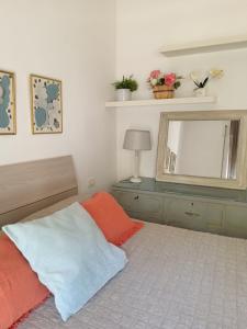- une chambre avec un lit et un miroir dans l'établissement Casa Flora appartamento con giardino, à Fiumicino