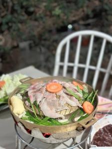 un pot de nourriture avec des carottes et des haricots verts dans l'établissement Ingmhok Resort, à Suan Phueng