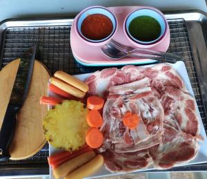 un plateau de nourriture avec de la viande, des légumes et de la sauce dans l'établissement Ingmhok Resort, à Suan Phueng