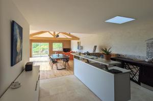 a kitchen and living room with a counter and a table at Terre de Sienne in Saint-Clair