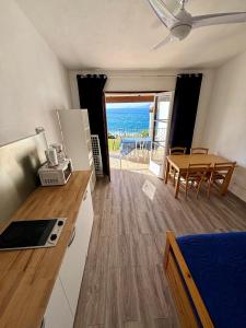 eine Küche und ein Esszimmer mit Meerblick in der Unterkunft Résidence Punta paliagi in Calcatoggio