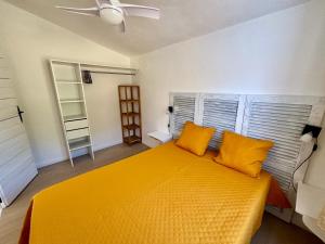 Résidence Punta paliagi في كالكاتوكجيو: غرفة نوم بسرير كبير مع مخدات صفراء