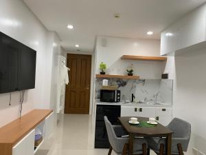 una cocina con una mesa pequeña y una cocina con mesa en Givande Studio at One PonteFino, en Batangas