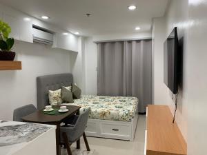 una pequeña sala de estar con cama y mesa. en Givande Studio at One PonteFino, en Batangas