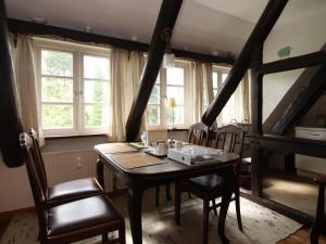 a dining room with a table and chairs and windows at Wohnung in Dorfmark nahe Lüneburger Heide in Dorfmark