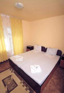 1 dormitorio con 1 cama con 2 toallas en Pensiunea HARTTAS, en Tulcea