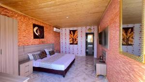 una camera con letto e TV a schermo piatto di Hôtel bergmann a Ouro Sogui