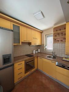 una cocina con armarios amarillos y fregadero en TOP Center Apartment, en Bitola