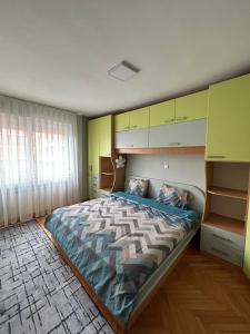 TOP Center Apartment في بيتولا: غرفة نوم بسرير كبير وجدران صفراء وأخضر