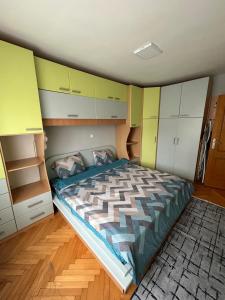 Dormitorio pequeño con cama y armarios en TOP Center Apartment, en Bitola