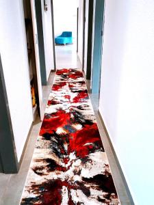 einen Flur mit einem roten und schwarzen Teppich auf dem Boden in der Unterkunft Reutlwane Gardens house in Secunda