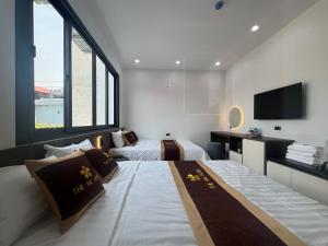a hotel room with two beds and a flat screen tv at The MC hotel mộc châu in Mộc Châu