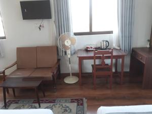 sala de estar con escritorio y mesa con ventilador en Dragon Hotel, en Pokhara