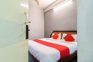 a bedroom with a bed with red pillows on it at OYO Flagship Hotel Achi in Tiruppūr