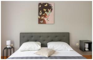 普利莫頓的住宿－M&Z Apartmani，卧室配有一张床,墙上挂有绘画作品