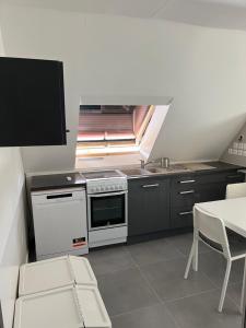 a kitchen with a stove and a sink and a table at Chambre privée Coatodon in Guipavas