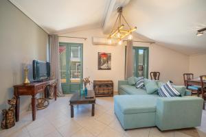 uma sala de estar com um sofá azul e uma televisão em The Square Suites 2nd floor apartment em Argostoli