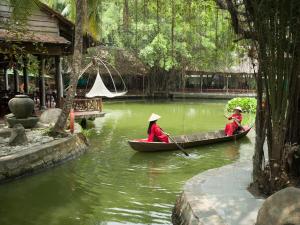 dos personas en un barco en un río con en Phuong Nam Resort, en Thuan An