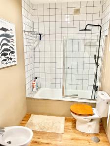a bathroom with a toilet and a bath tub at La Casa de los Libros in Muros de Nalón
