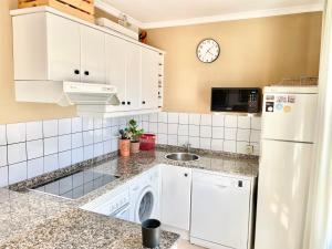 a kitchen with a white refrigerator and a dishwasher at La Casa de los Libros in Muros de Nalón